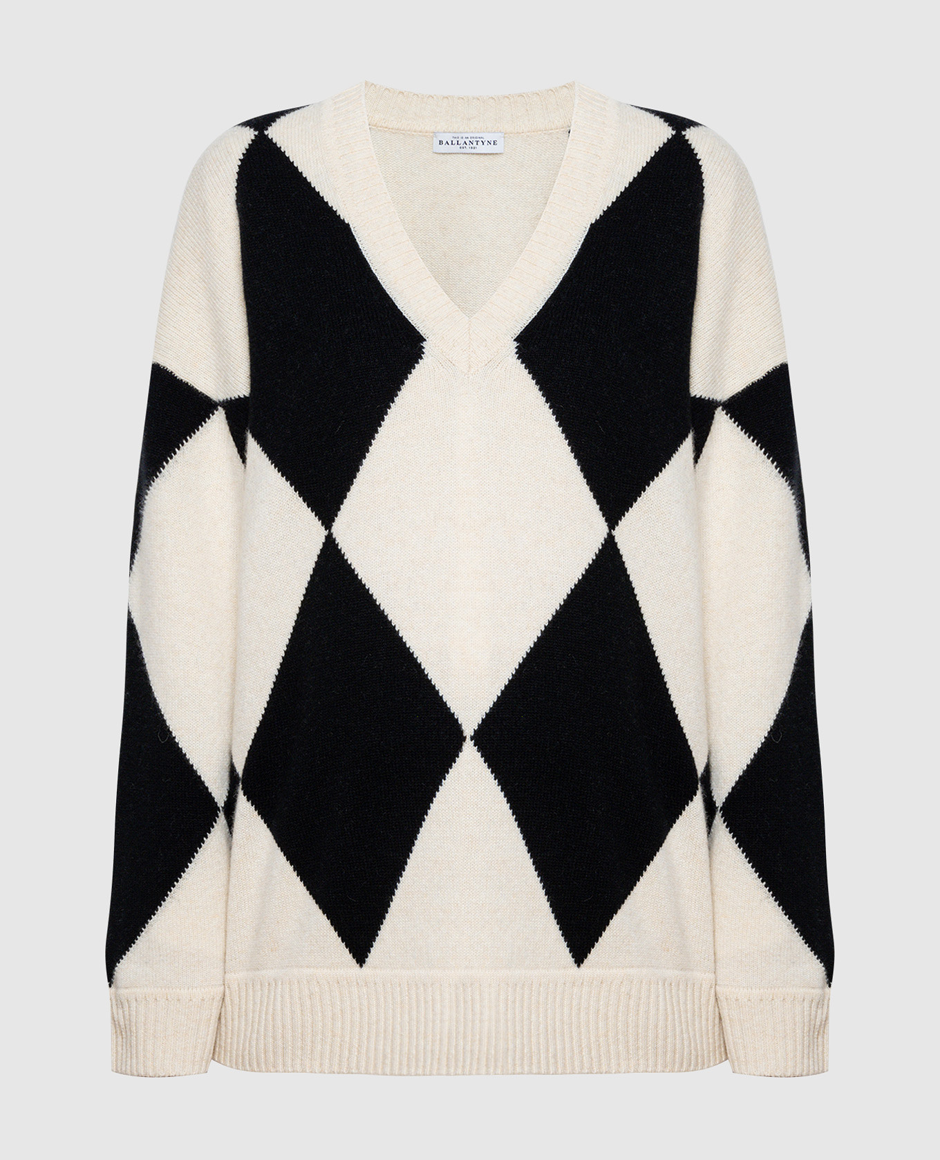 Белый пуловер из шерсти с геометрическим узором.