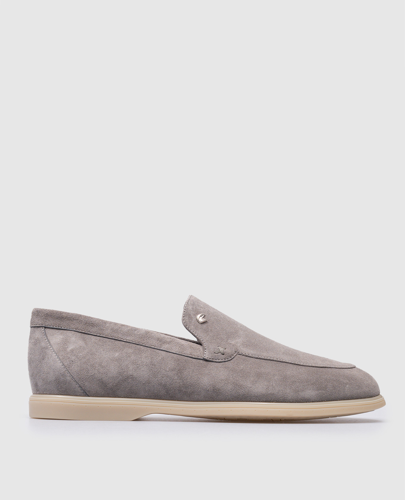 Gray suede loafers with metallic logo patch